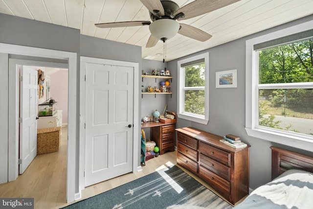 bedroom with multiple windows, wood finished floors, wooden ceiling, and a ceiling fan