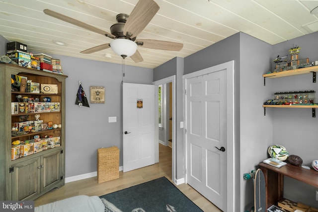 bedroom with light wood finished floors, baseboards, and ceiling fan