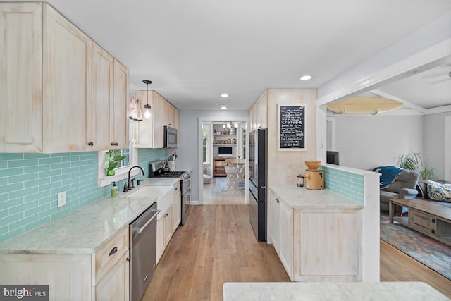kitchen with stainless steel appliances, light wood-style flooring, decorative backsplash, light brown cabinetry, and recessed lighting