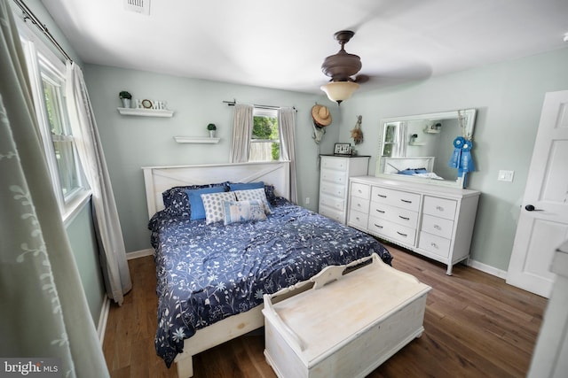bedroom with wood finished floors, baseboards, and a ceiling fan