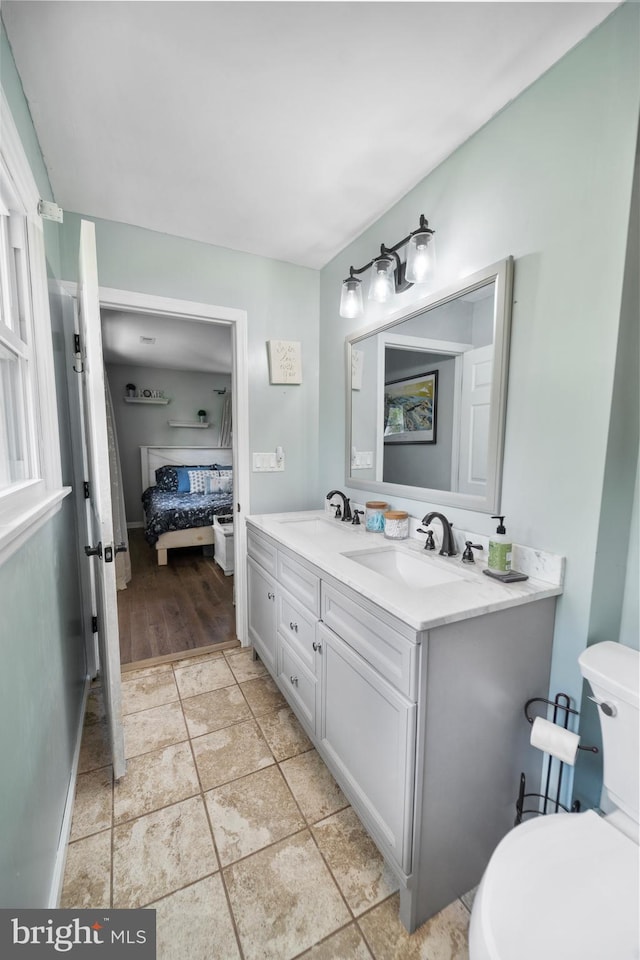 ensuite bathroom featuring toilet and double vanity