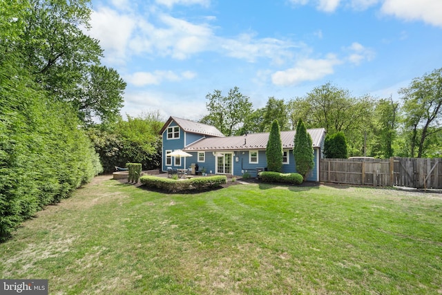 rear view of property with a patio area and metal roof