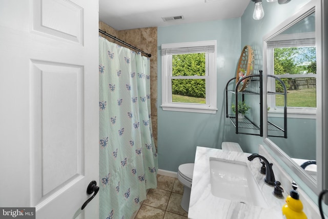 bathroom featuring a sink, tile patterned flooring, toilet, and a shower with curtain