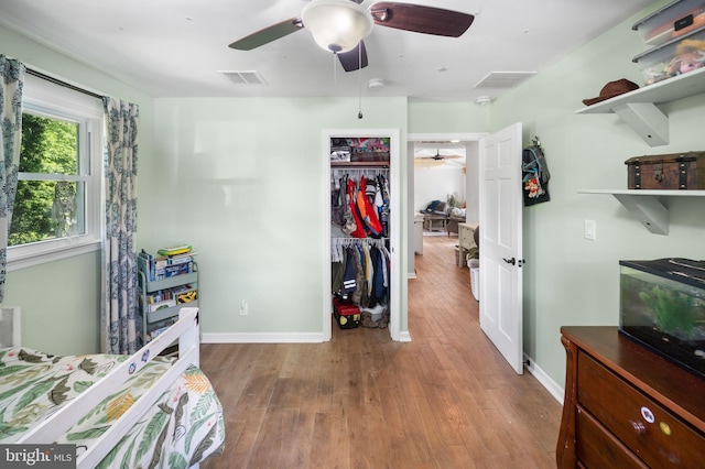 bedroom featuring wood finished floors, baseboards, a closet, and a ceiling fan