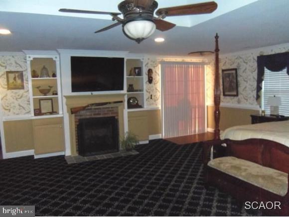38802 Tyler Ave, Selbyville, DE 19975 - bedroom featuring wallpapered walls, dark colored carpet, a brick fireplace, baseboards, and recessed lighting