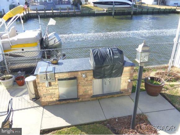 38802 Tyler Ave, Selbyville, DE 19975 - dock featuring an outdoor kitchen, a water view, and a patio