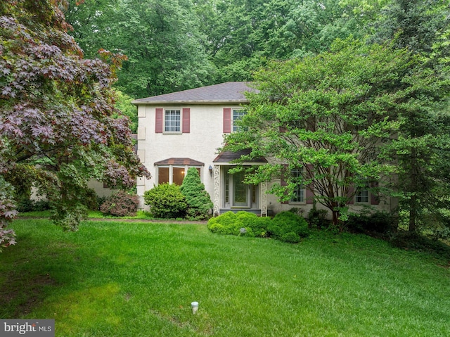 view of front of house with a front lawn and stucco siding