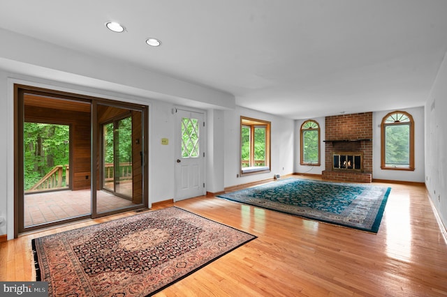 living room with hardwood / wood-style floors, baseboards, recessed lighting, and a fireplace