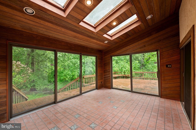 unfurnished sunroom with vaulted ceiling, a skylight, and healthy amount of natural light