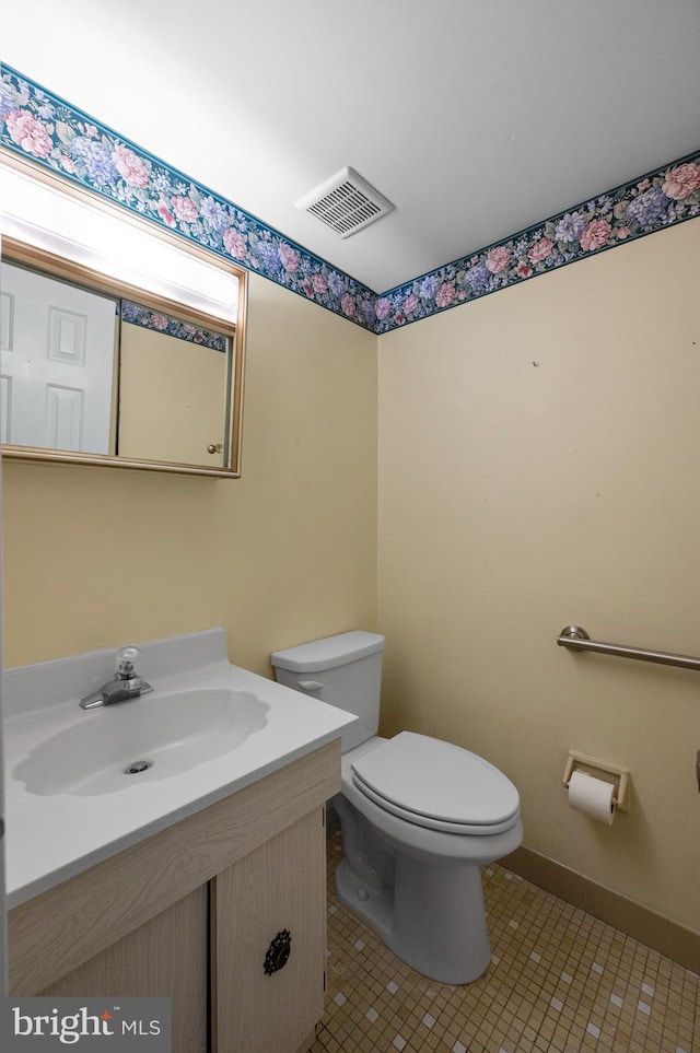 bathroom with toilet, tile patterned flooring, vanity, and baseboards