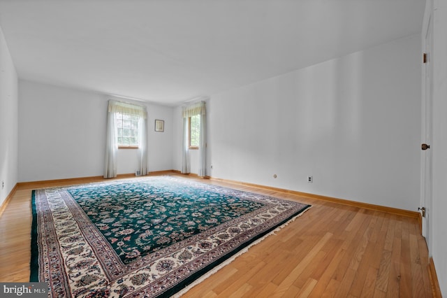 spare room featuring light wood-style flooring and baseboards