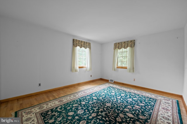 empty room featuring wood finished floors and baseboards