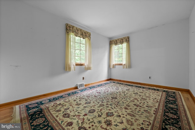 spare room featuring wood finished floors and baseboards