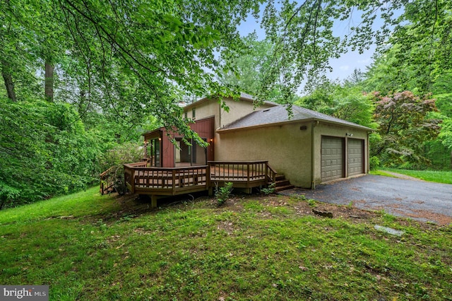 view of side of property featuring stucco siding, a wooden deck, and a garage