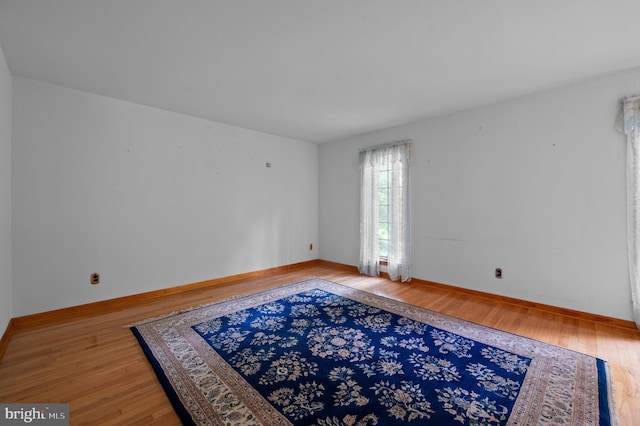 empty room featuring wood finished floors and baseboards