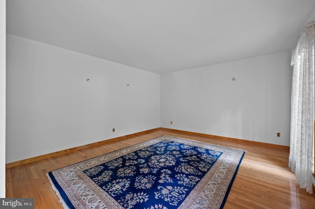 spare room with hardwood / wood-style flooring and baseboards