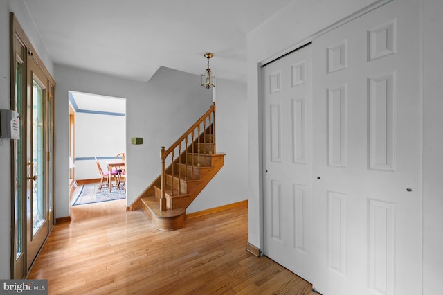 staircase with healthy amount of natural light, wood finished floors, and baseboards
