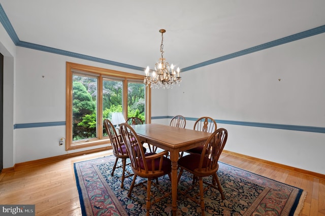 dining room with a chandelier, baseboards, crown molding, and light wood-type flooring