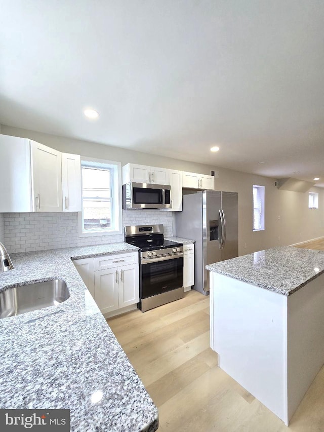 1937 Mayland St, Philadelphia, PA 19138 - kitchen with stainless steel appliances, a sink, white cabinets, backsplash, and light stone counters