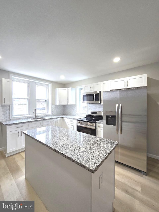 1937 Mayland St, Philadelphia, PA 19138 - kitchen with stainless steel appliances, a sink, light wood-style floors, a kitchen island, and backsplash