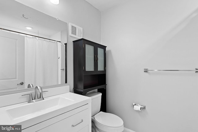 bathroom with toilet, vanity, and baseboards
