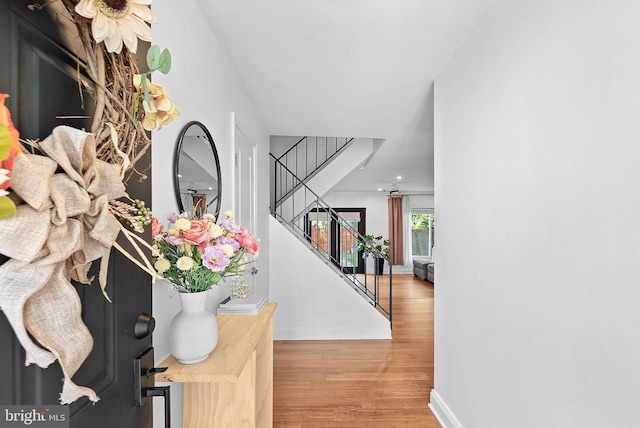 foyer with stairway, wood finished floors, and baseboards