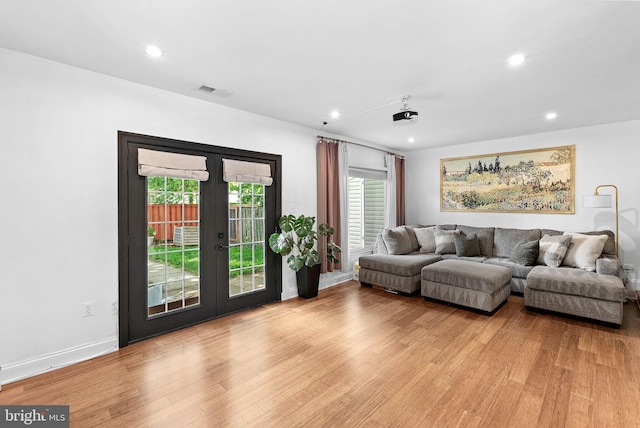 living room with light wood-type flooring, recessed lighting, french doors, and baseboards