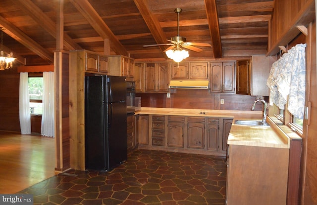 kitchen featuring freestanding refrigerator, wooden ceiling, a sink, under cabinet range hood, and light countertops
