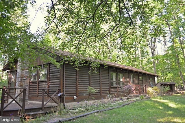 view of home's exterior with a lawn and log siding
