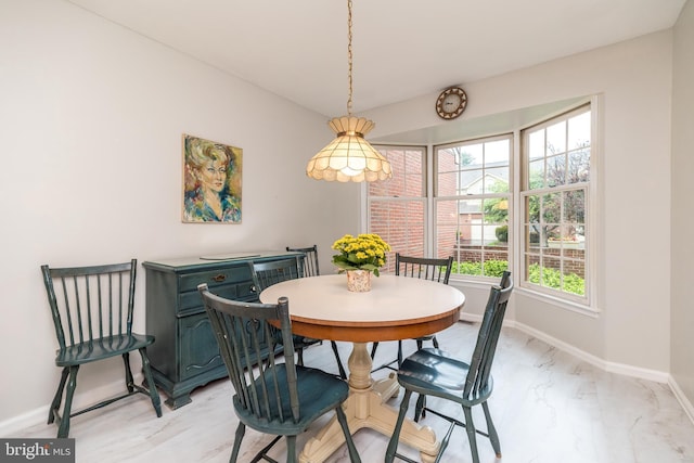 dining area with baseboards and light marble finish flooring