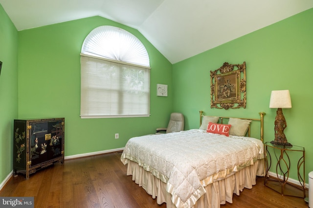 bedroom featuring wood finished floors, lofted ceiling, and baseboards