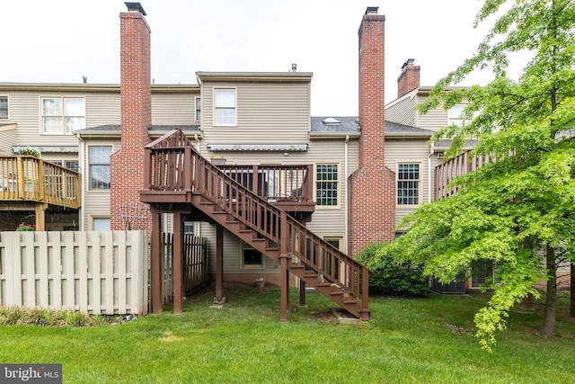 back of property featuring stairs, a wooden deck, and a chimney