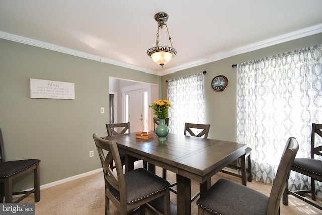 dining area featuring crown molding, light colored carpet, and baseboards
