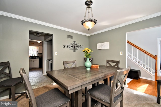 dining room featuring crown molding and stairs