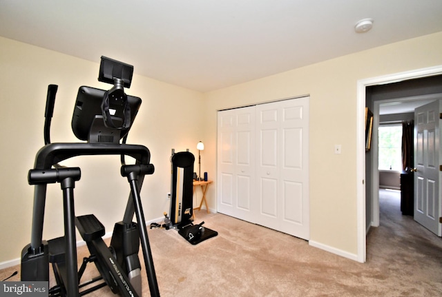 exercise room featuring carpet and baseboards