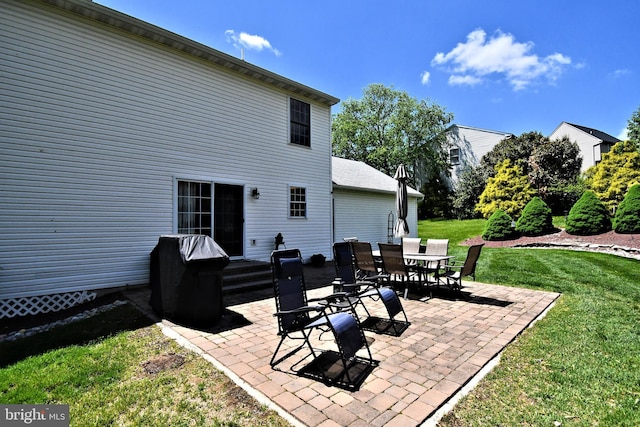 back of property with a patio, a yard, and outdoor dining area