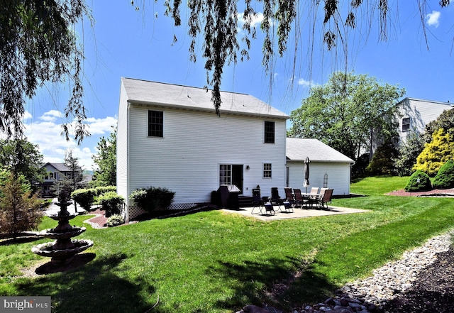 rear view of house with a patio and a lawn