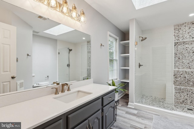 16110 Amethyst Ln, Bowie, MD 20716 - bathroom featuring a skylight, wood finished floors, vanity, tiled shower, and recessed lighting