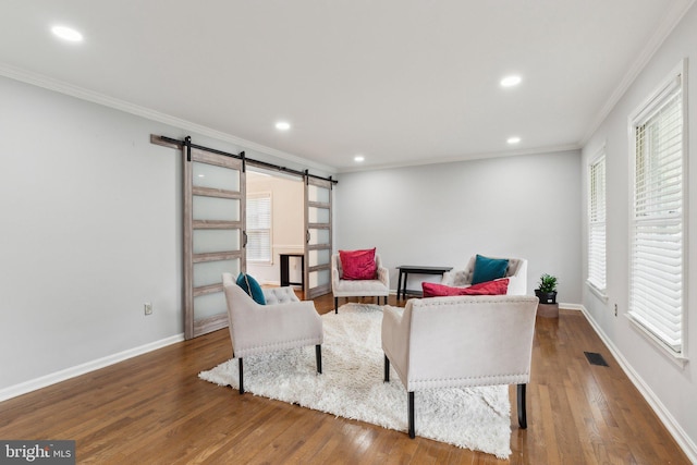 16110 Amethyst Ln, Bowie, MD 20716 - living area with a barn door, plenty of natural light, crown molding, wood finished floors, and recessed lighting