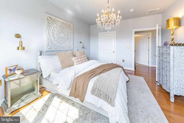12800 Libertys Delight Dr Unit 403, Bowie, MD 20720 - bedroom featuring a chandelier, wood finished floors, and baseboards