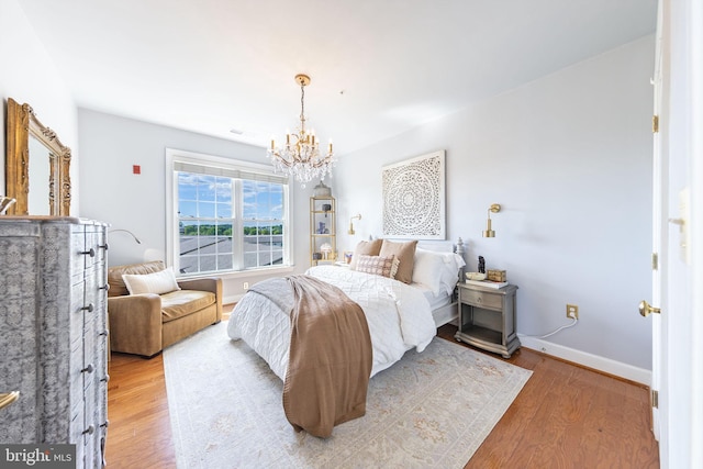 12800 Libertys Delight Dr Unit 403, Bowie, MD 20720 - bedroom with a chandelier, light wood-type flooring, and baseboards