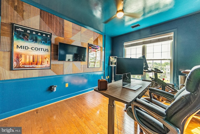 office space with a ceiling fan, hardwood / wood-style floors, and baseboards