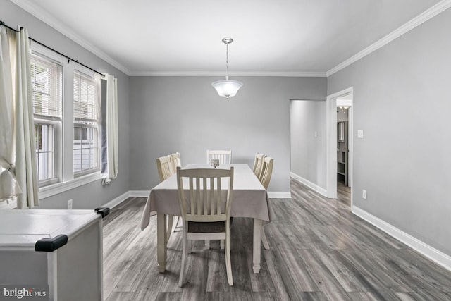 dining room featuring wood finished floors, baseboards, and ornamental molding