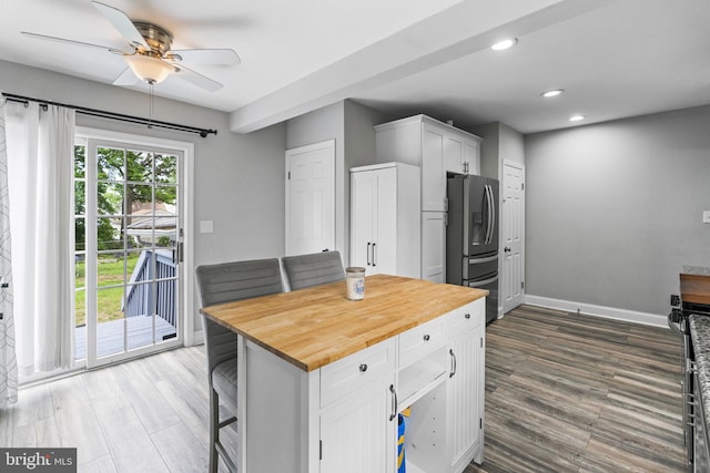 kitchen with butcher block countertops, a ceiling fan, stainless steel refrigerator with ice dispenser, white cabinetry, and dark wood-style flooring
