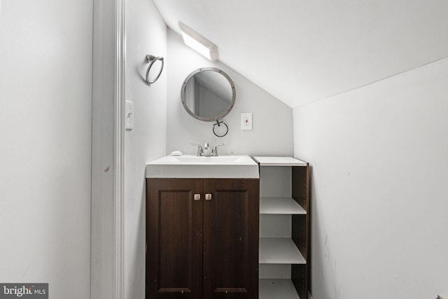 bathroom with lofted ceiling and vanity