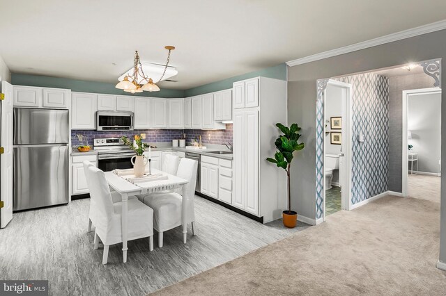 2021 Rudy Serra Dr Unit 1D, Eldersburg, MD 21784 - kitchen with appliances with stainless steel finishes, white cabinetry, decorative backsplash, and baseboards