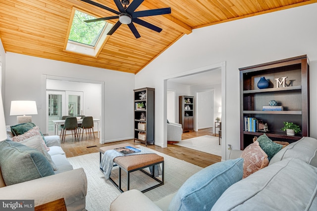 living area featuring wood ceiling, a skylight, ceiling fan, light wood-type flooring, and baseboards