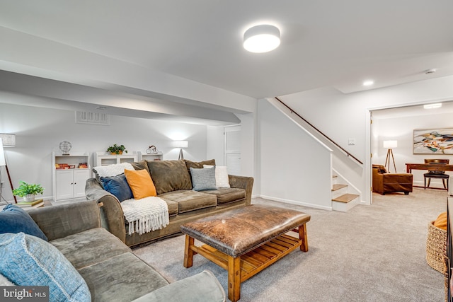 living room with stairs, light carpet, and baseboards