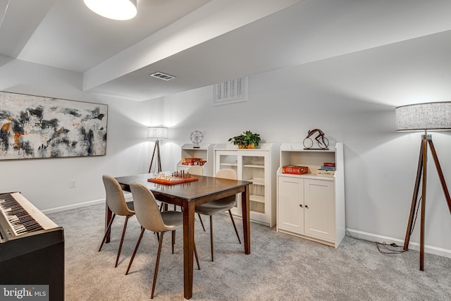 dining space with light colored carpet and baseboards