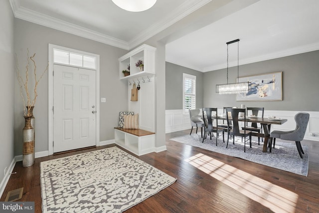 entrance foyer featuring dark wood-style floors, crown molding, and a wainscoted wall